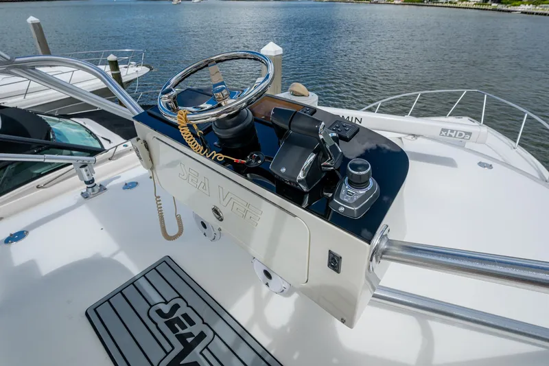 Slide: The Image of 2014 SeaVee 430 boat helm with steering wheel and controls, docked by the water. - 46
