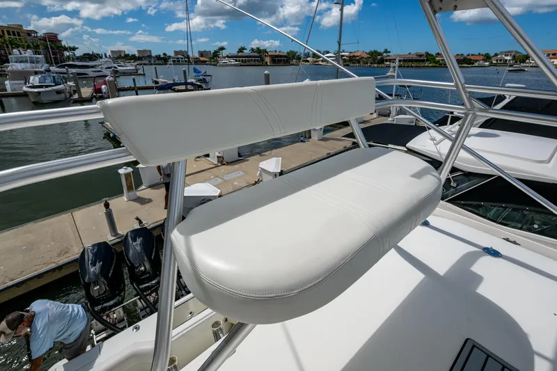 Slide: The Image of 2014 SeaVee 430 boat with white seating at a marina dock. - 48