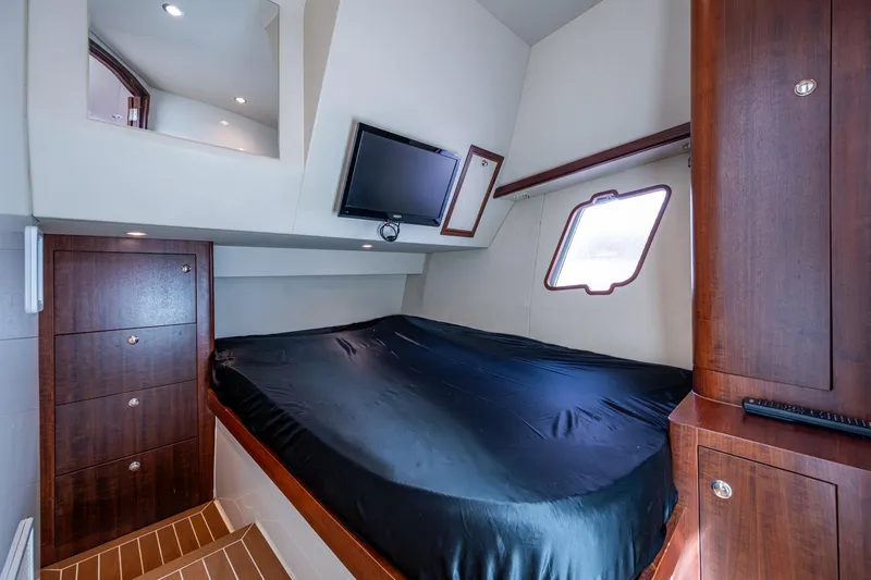Slide: The Image of Luxurious cabin interior of 2014 SeaVee 430 with bed, TV, and wooden cabinetry. - 59