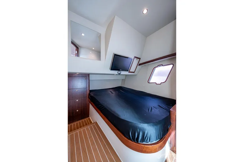 Slide: The Image of 2014 SeaVee 430 cabin interior with bed, TV, and wooden flooring. - 60