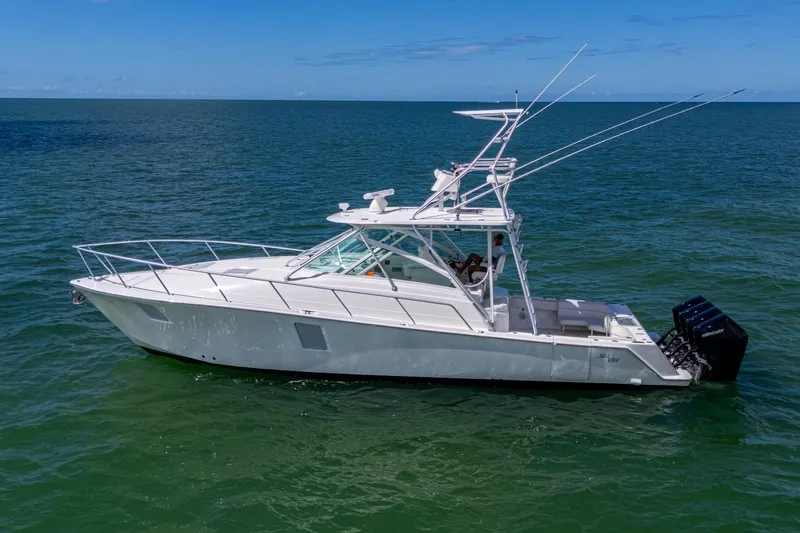 Slide: The Image of 2014 SeaVee 430 boat on open water, featuring sleek design and multiple outboard engines. - 8