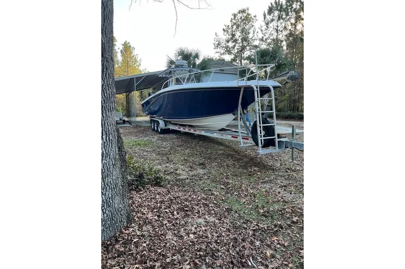 The Image of 2006 Fountain 38 Tournament Edition boat on trailer in wooded area. - 0