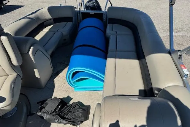 Slide: The Image of 2019 Barletta E22Q SS pontoon boat interior with beige seating and blue mat. - 4
