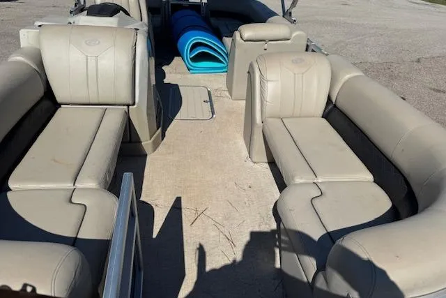 Slide: The Image of 2019 Barletta E22Q SS pontoon boat interior with beige seating and blue mats. - 5