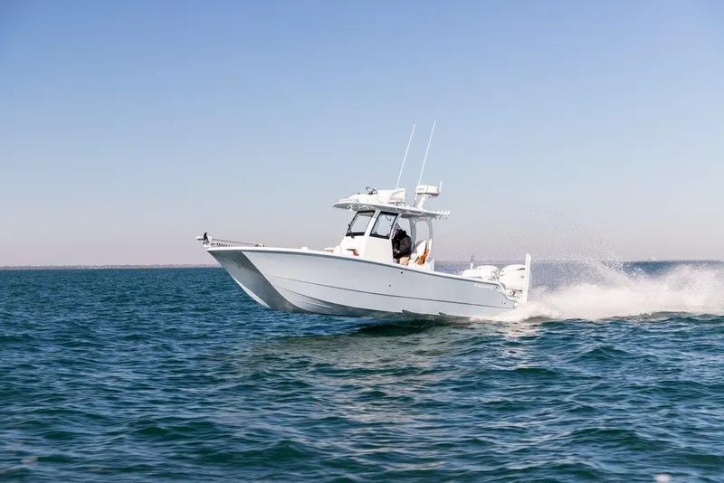 The Image of 2024 Freeman 28 boat cruising on open water under clear blue sky. - 0