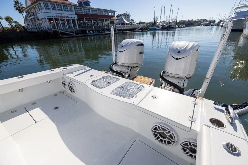 Slide: The Image of 2024 Freeman 28 boat with dual engines docked near waterfront restaurant. - 1