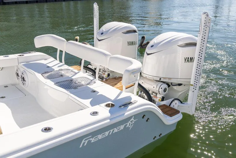 Slide: The Image of 2024 Freeman 28 boat with dual Yamaha outboard engines on calm water. - 2