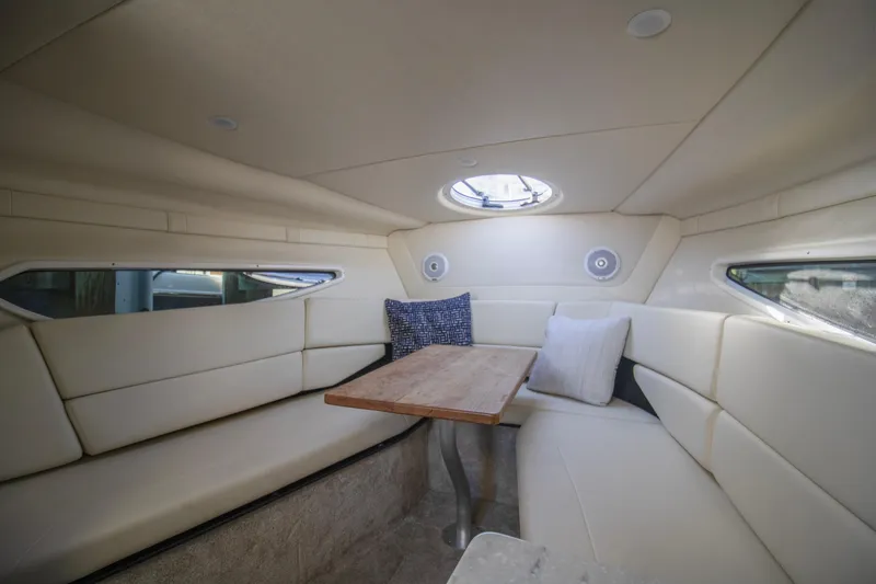 Slide: The Image of 2020 Regal 26 XO boat interior with cozy seating and wooden table. - 2