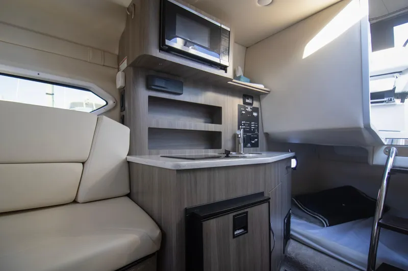 Slide: The Image of 2020 Regal 26 XO boat interior with kitchenette, microwave, and seating area. - 3