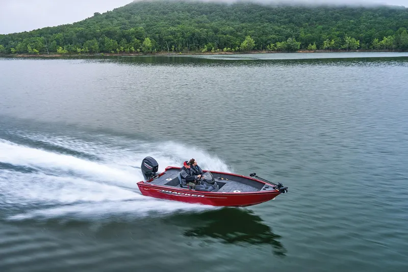 Slide: The Image of Manufacturer Provided Image: 2026 Tracker Super Guide V-16 SC boat speeding on a lake with forested hills in the background. - 32