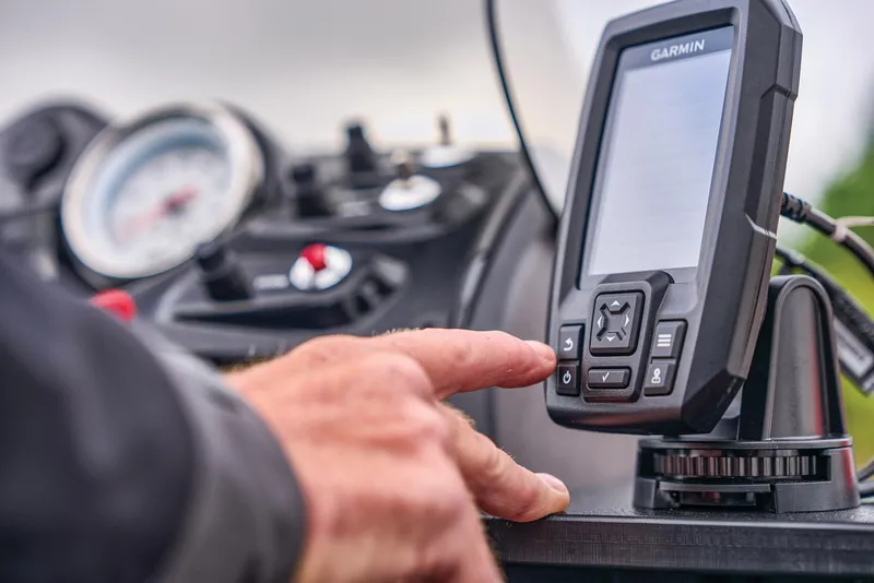 Slide: The Image of Manufacturer Provided Image: Hand operating Garmin device on 2026 Tracker Super Guide V-16 SC dashboard. - 38