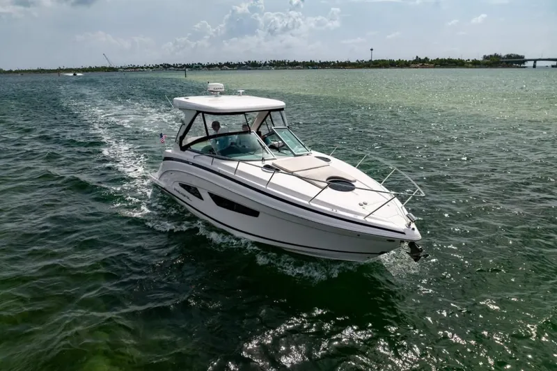 Slide: The Image of 2021 Regal 33 OBX boat cruising on open water under a cloudy sky. - 3