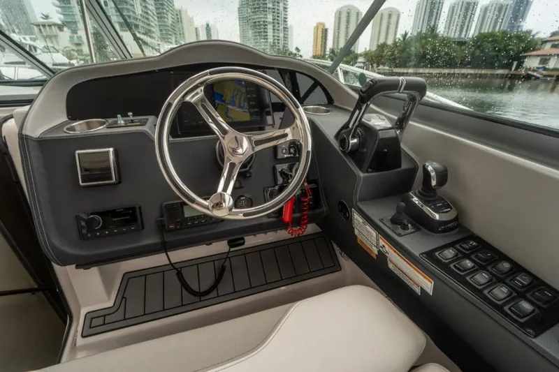 Slide: The Image of 2021 Regal 33 OBX boat cockpit with steering wheel and control panel. - 4