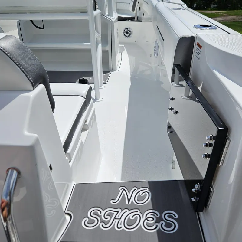 Slide: The Image of 2019 Blackfin 222 CC boat interior with "No Shoes" sign on deck. - 13