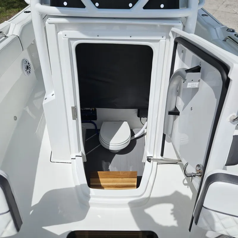 Slide: The Image of 2019 Blackfin 222 CC boat interior with open door revealing compact marine toilet. - 14