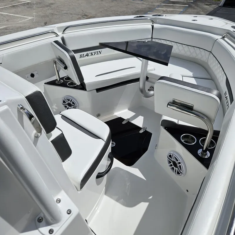 Slide: The Image of 2019 Blackfin 222 CC boat interior with seating, table, and cup holders. - 21