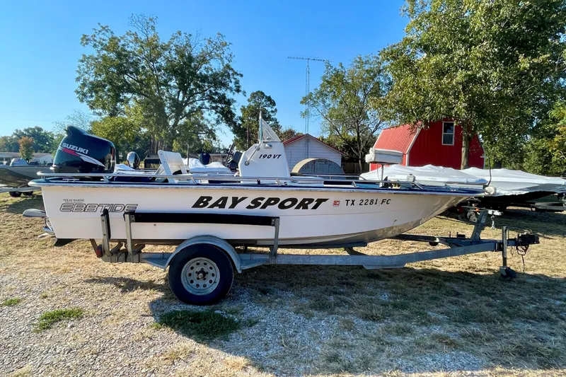 Slide: The Image of 1997 Ebbtide 190 SV Bay Sport boat on trailer, outdoors with trees and red barn. - 0