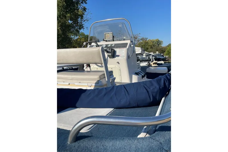 Slide: The Image of 1997 Ebbtide 190 SV boat interior with steering console and seating, under clear blue sky. - 6