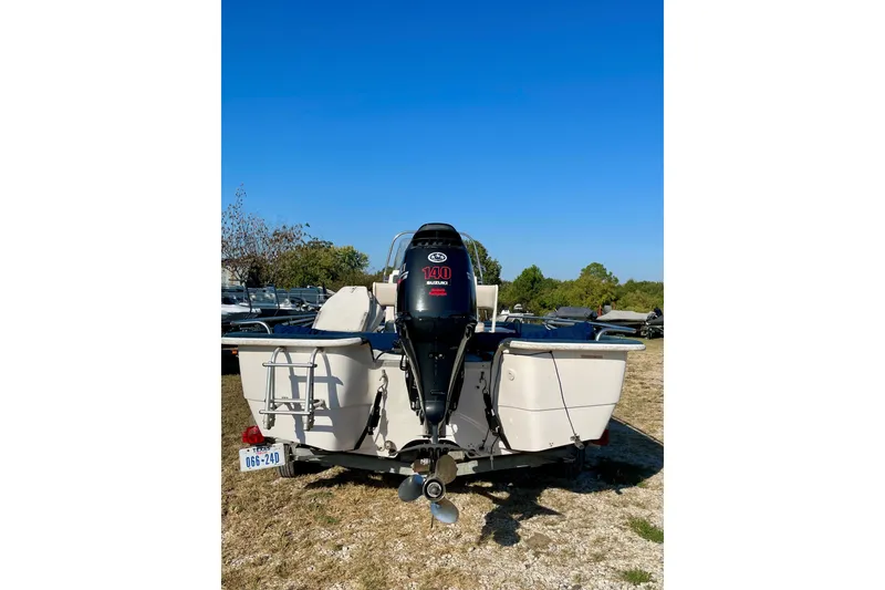 Slide: The Image of 1997 Ebbtide 190 SV boat with outboard motor, parked on grass under clear blue sky. - 9