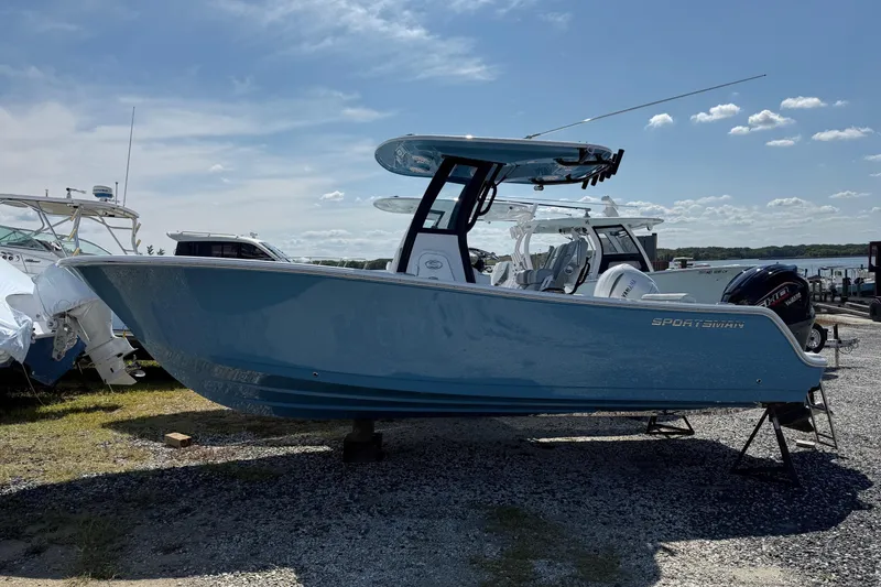 The Image of 2026 Sportsman Open 232 Center Console boat in a marina setting under a clear sky. - 0
