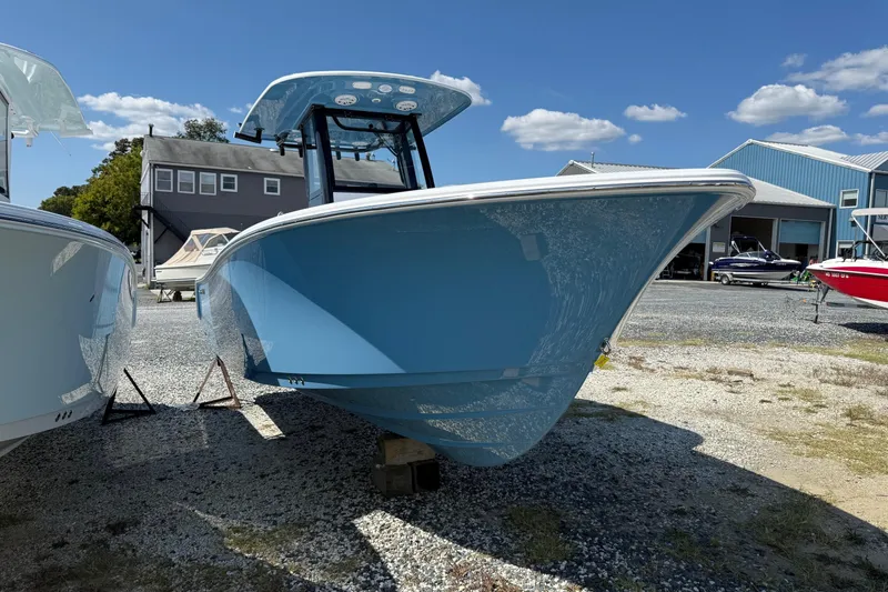 Slide: The Image of 2026 Sportsman Open 232 Center Console boat on display outdoors, blue hull, sunny day. - 2