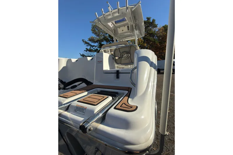 Slide: The Image of 2018 Sea Fox 248 Commander boat interior with helm and seating, under clear blue sky. - 15
