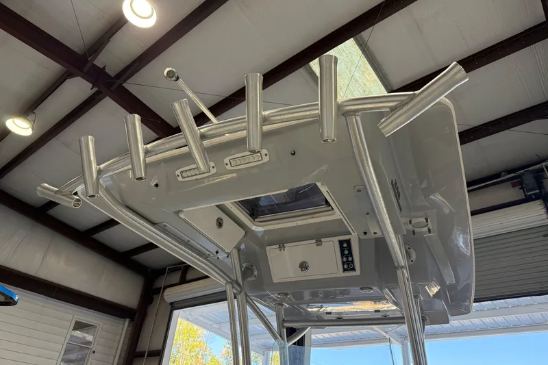 Slide: The Image of 2018 Sea Fox 248 Commander boat T-top with rod holders in a garage setting. - 25