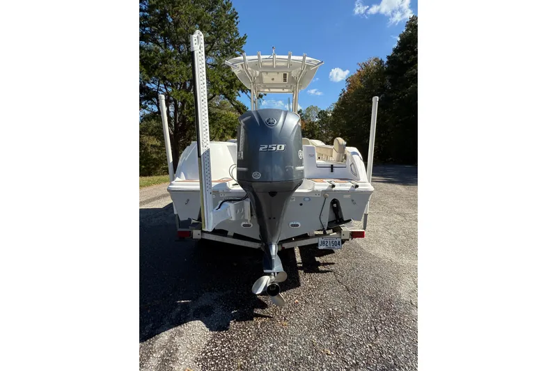Slide: The Image of 2018 Sea Fox 248 Commander boat on trailer, parked near trees under clear blue sky. - 5