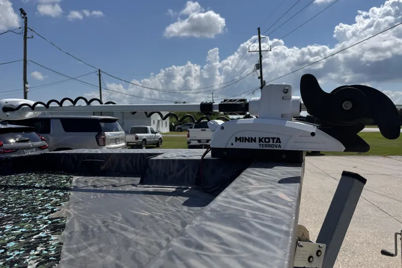 Slide: The Image of 2022 Alweld 2270 boat with Minn Kota Terrova motor, parked outdoors under a sunny sky. - 8