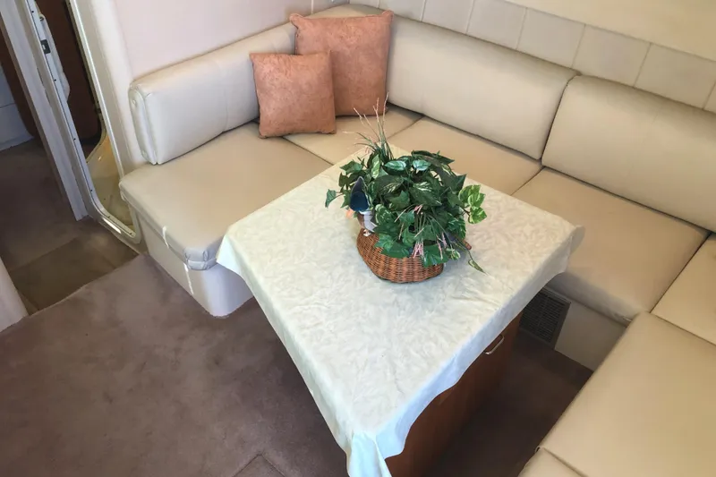 Slide: The Image of Interior of 1999 Mainship 31 Sedan Bridge with beige seating and table centerpiece. - 12