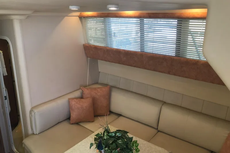 Slide: The Image of Interior of 1999 Mainship 31 Sedan Bridge with beige seating and decorative pillows. - 13