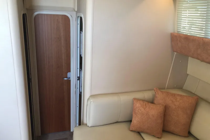 Slide: The Image of Interior of 1999 Mainship 31 Sedan Bridge with beige seating and wooden door. - 14