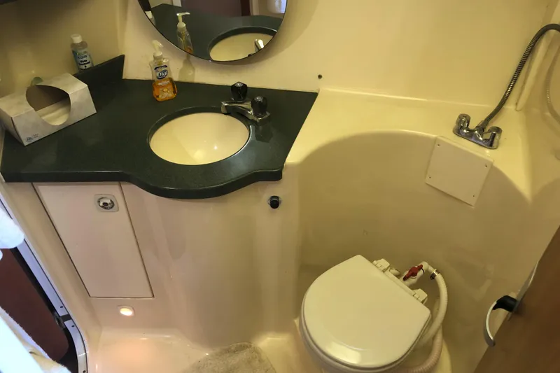 Slide: The Image of 1999 Mainship 31 Sedan Bridge bathroom with sink, mirror, and toilet. - 16