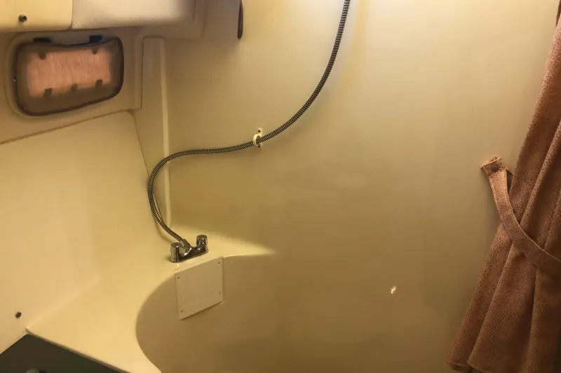 Slide: The Image of 1999 Mainship 31 Sedan Bridge bathroom with showerhead and towel. - 18