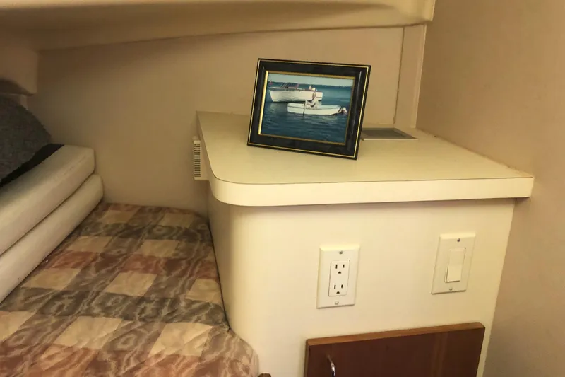 Slide: The Image of Interior of 1999 Mainship 31 Sedan Bridge with framed boat photo on shelf. - 27