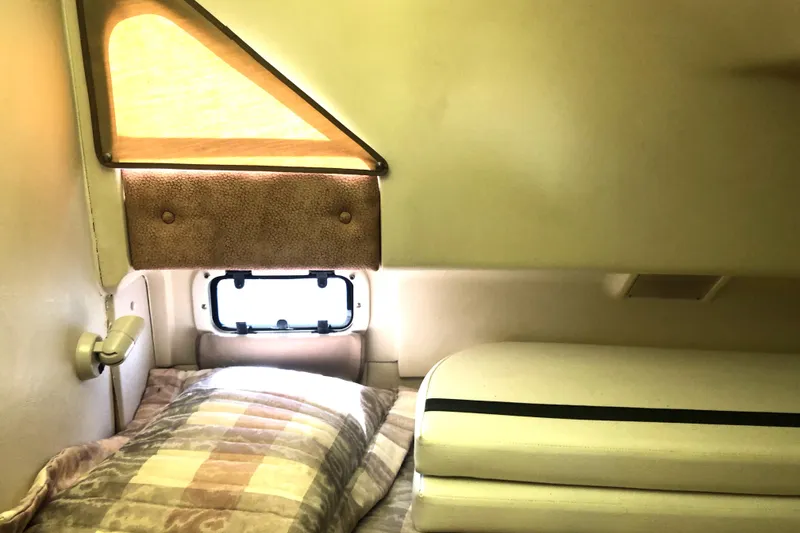 Slide: The Image of 1999 Mainship 31 Sedan Bridge cabin interior with bed, window, and lamp. - 28