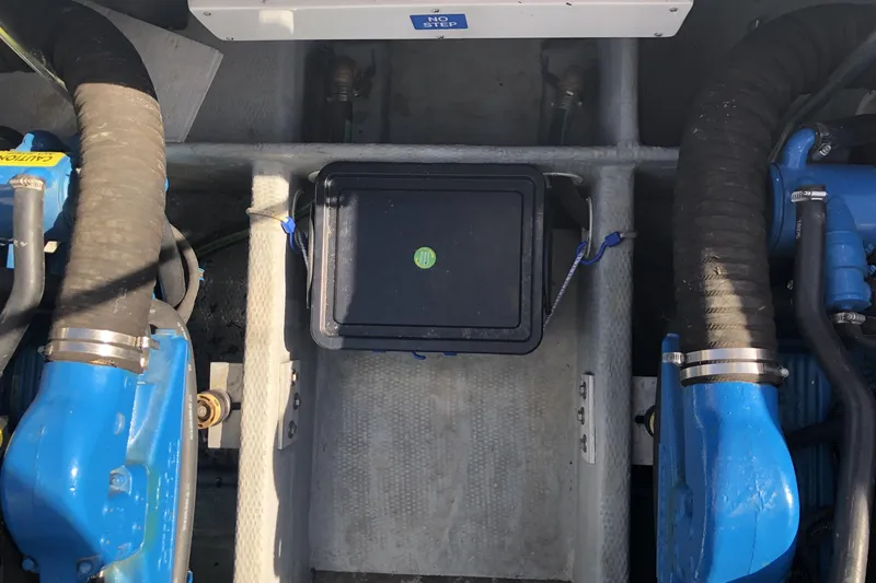 Slide: The Image of Engine compartment of a 1999 Mainship 31 Sedan Bridge with blue components. - 43