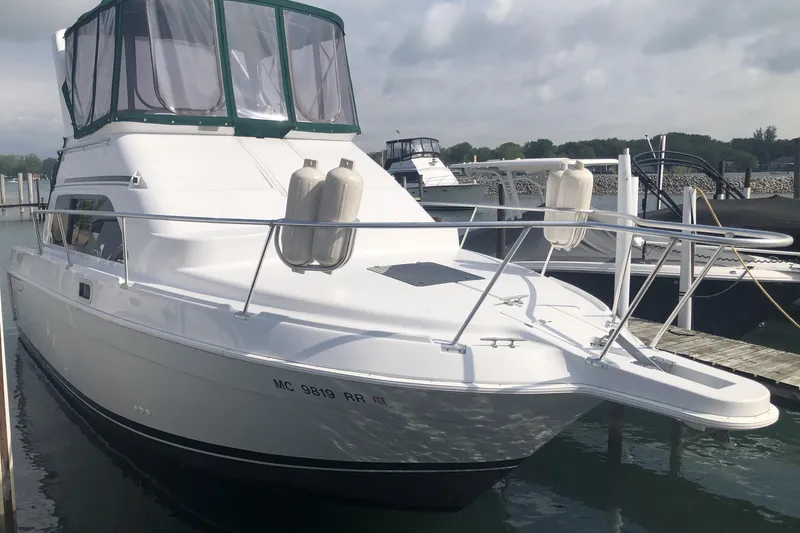 Slide: The Image of 1999 Mainship 31 Sedan Bridge yacht docked at marina under cloudy sky. - 6