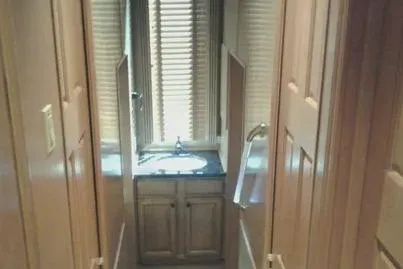 Slide: The Image of Narrow hallway leading to a bathroom with wooden cabinets in a 2007 Sumerset Steelaway. - 9