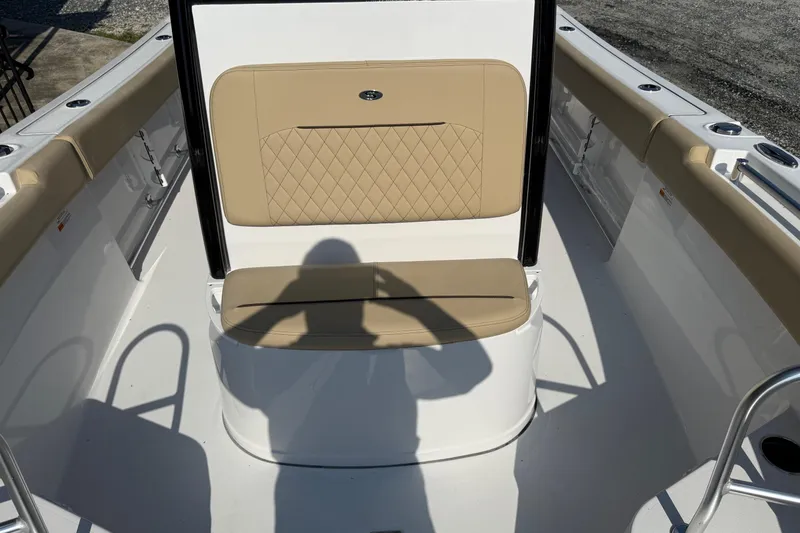 Slide: The Image of 2026 Sportsman Open 232 Center Console boat interior with tan seating and shadow. - 12
