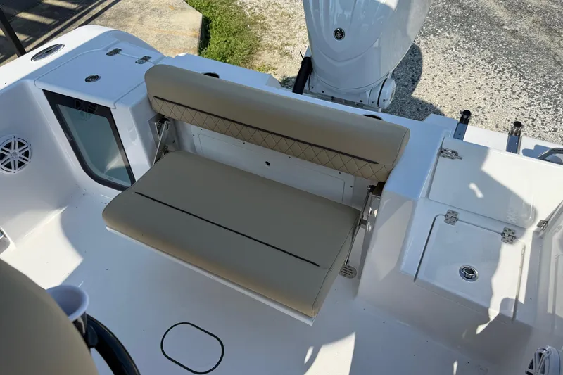 Slide: The Image of 2026 Sportsman Open 232 Center Console boat interior with beige seating and storage compartments. - 5