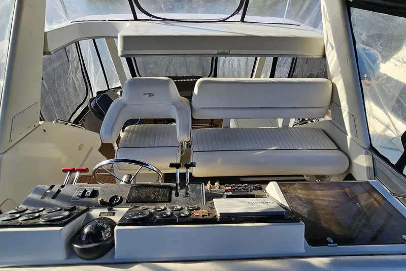 Slide: The Image of 1995 Carver 355 Aft Cabin Motor Yacht helm with controls and seating. - 10
