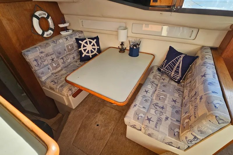 Slide: The Image of Cozy dining area in 1995 Carver 355 Aft Cabin Motor Yacht with nautical-themed decor. - 19