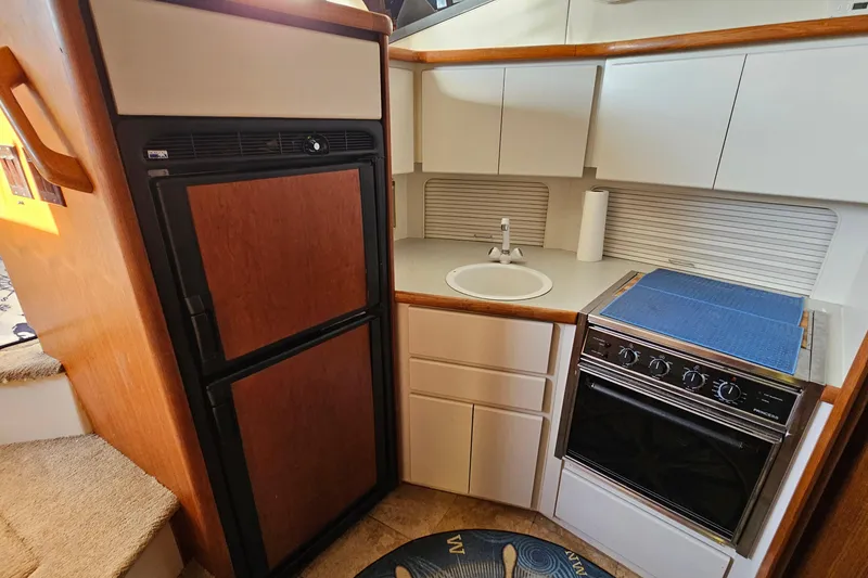 Slide: The Image of 1995 Carver 355 Aft Cabin Motor Yacht kitchen with stove, sink, and refrigerator. - 21