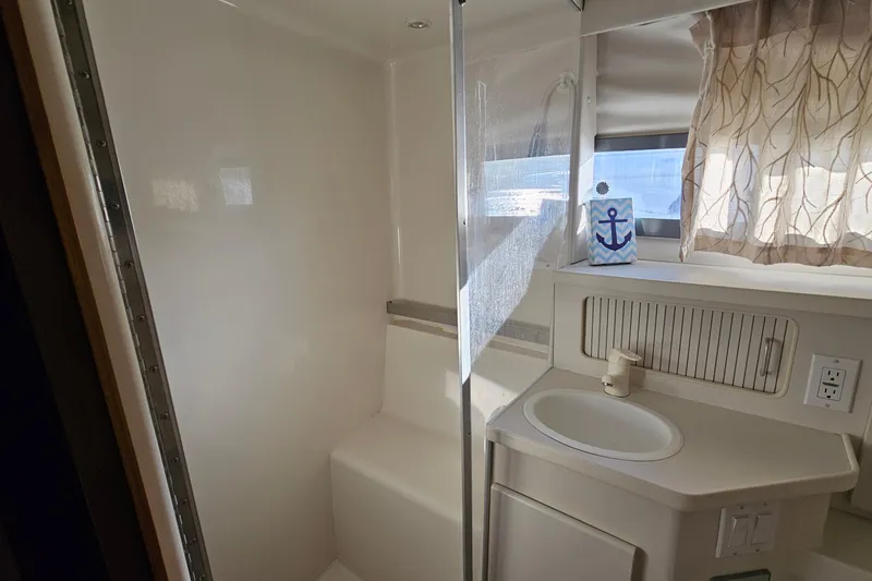 Slide: The Image of 1995 Carver 355 Aft Cabin Motor Yacht bathroom with shower, sink, and nautical decor. - 30