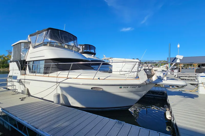 The Image of 1995 Carver 355 Aft Cabin Motor Yacht docked at marina under clear blue sky. - 1