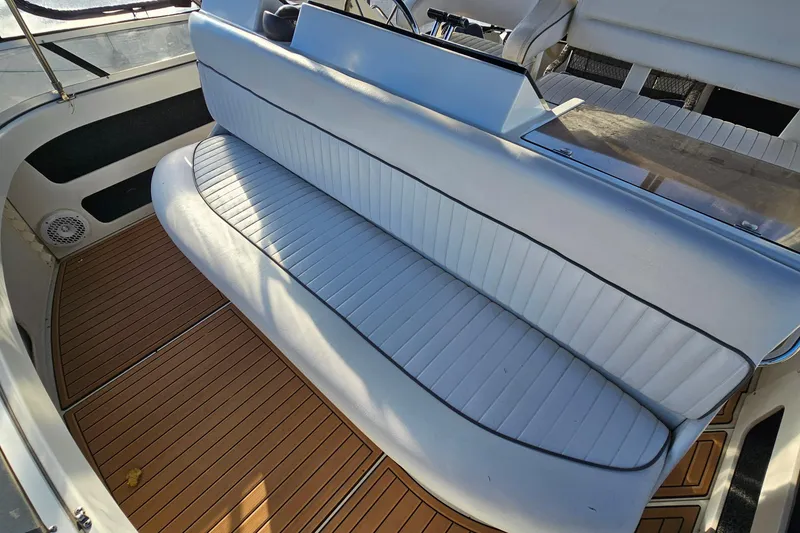 Slide: The Image of 1995 Carver 355 Aft Cabin Motor Yacht interior with white seating and wood flooring. - 12