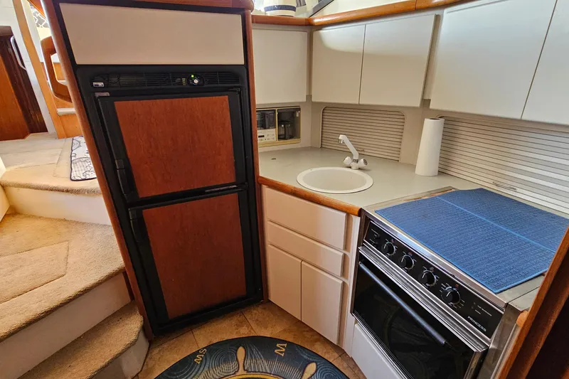 Slide: The Image of 1995 Carver 355 Aft Cabin Motor Yacht kitchen with stove, sink, and refrigerator. - 22
