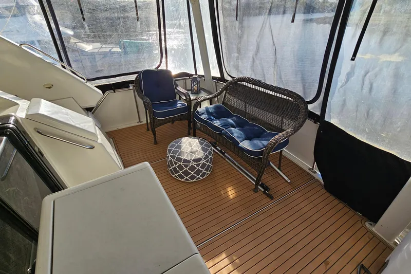 Slide: The Image of 1995 Carver 355 Aft Cabin Motor Yacht interior with wicker seating and scenic water view. - 6