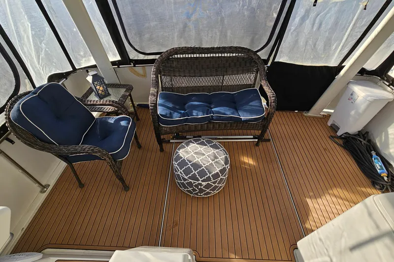 Slide: The Image of 1995 Carver 355 Aft Cabin Motor Yacht interior with wicker seating and blue cushions. - 7